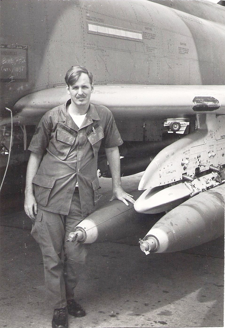 SSGT Bogart standing by a F-4 loaded with mark 82's 500 lb. bombs