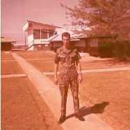Dan Massola in hootch area. (Note the base gym in the background.)